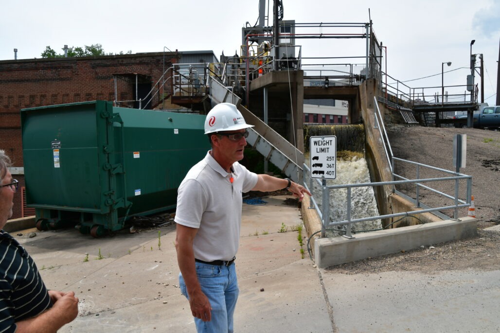 Male Engineer explaining raking process at hydro electric dam